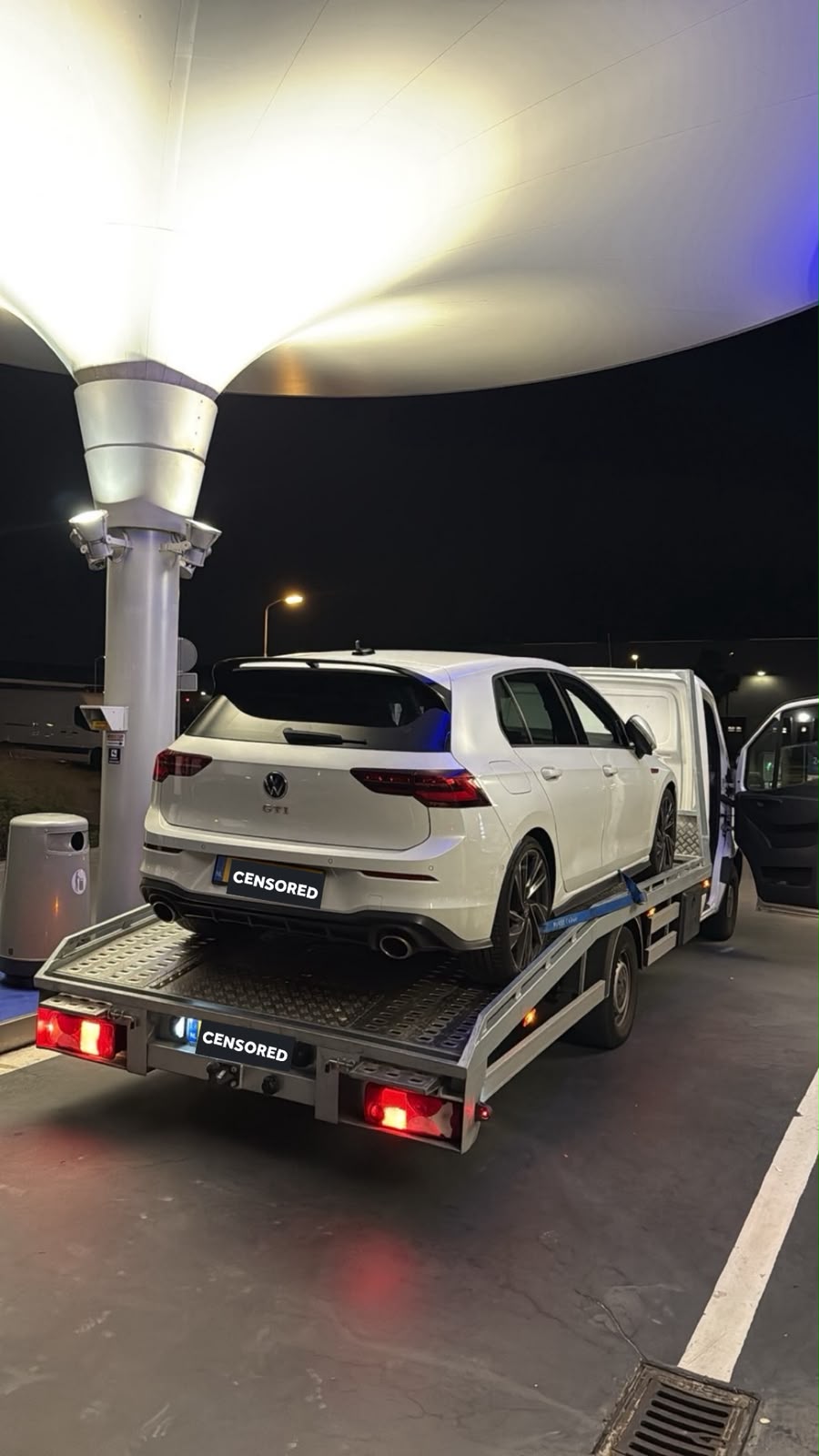 Witte Volkswagen Golf GTI 's nachts op de oprijwagen